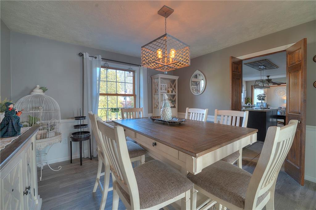257 Arbor Hill Road Greensburg, PA 15601 - Photo 6 of 26 a dining room with wooden floor a chandelier a wooden table and chairs