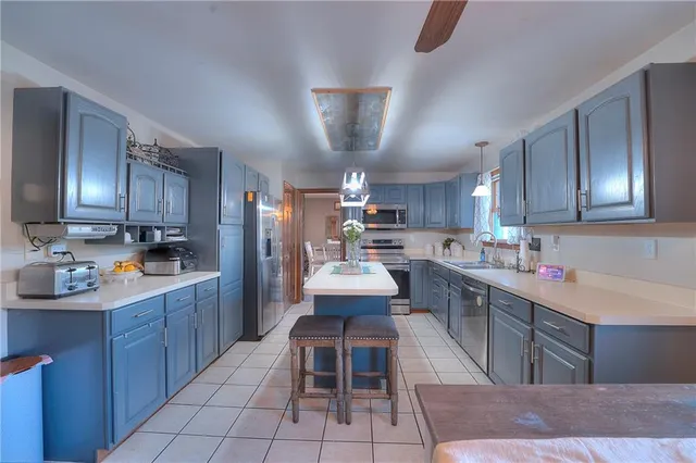 a kitchen with cabinets a sink stainless steel appliances and dining table