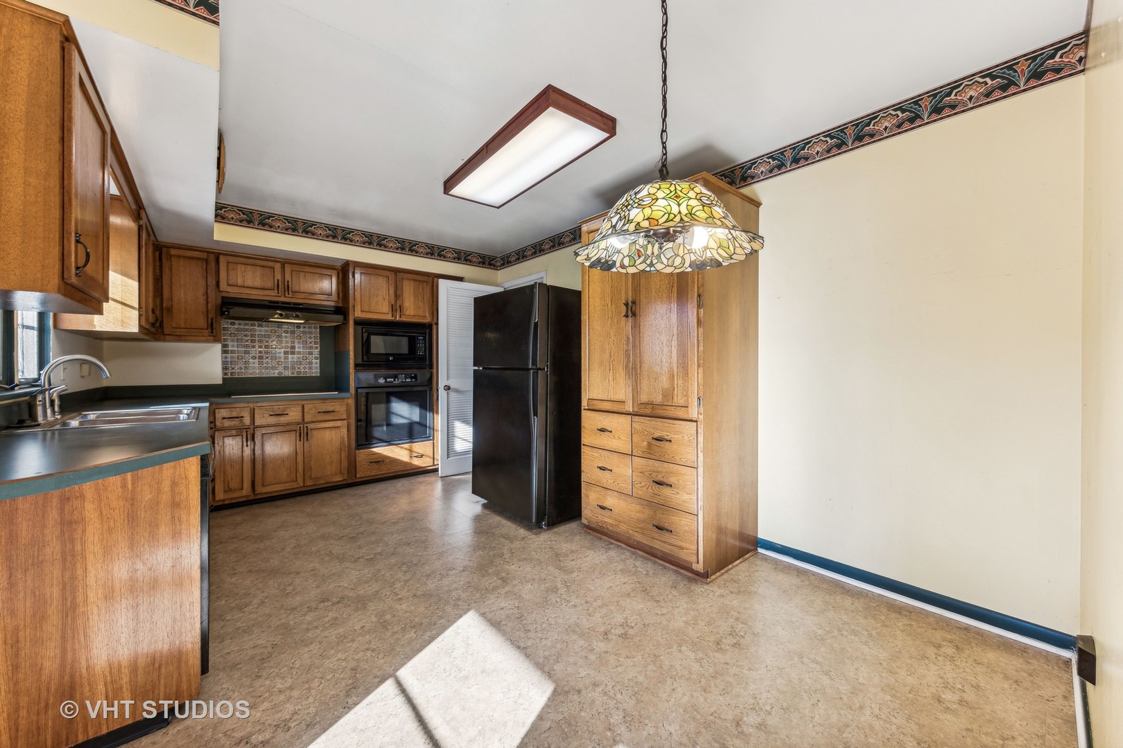 450 West Gartner Road Naperville, IL 60540 - Photo 5 of 31 a view of a kitchen with a sink and a refrigerator