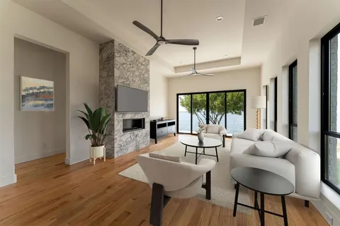 a living room with furniture a large window and wooden floor