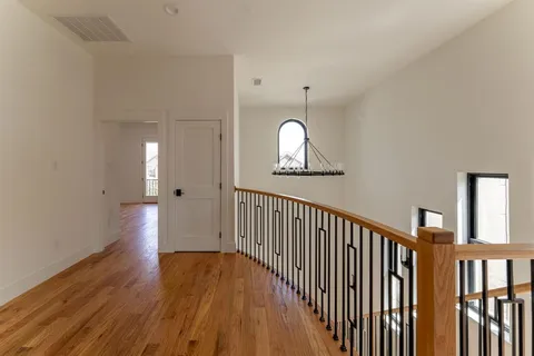 a view of a hallway with wooden floor