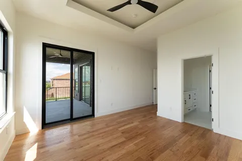 an empty room with wooden floor and sliding door