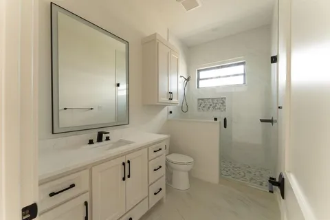 a bathroom with a double vanity sink mirror and toilet