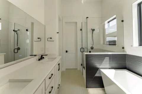 a bathroom with a tub a sink and mirror