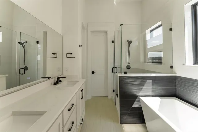 a bathroom with a tub a sink and mirror