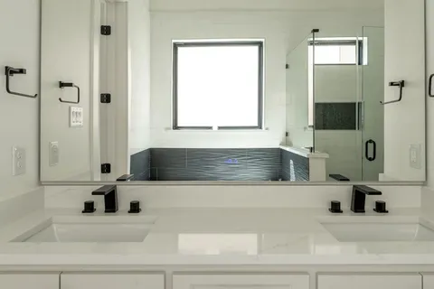 a bathroom with a tub sink and mirror