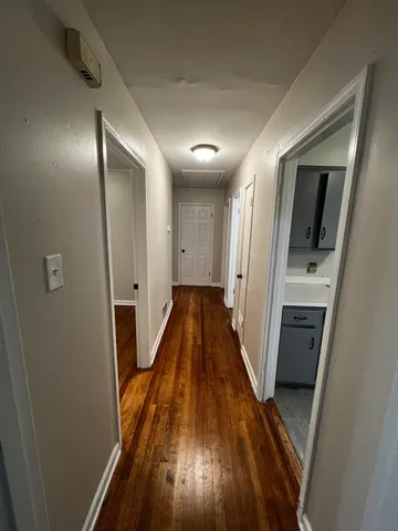a view of a hallway with wooden floor and staircase