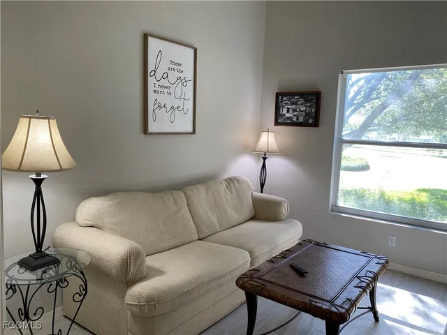a living room with furniture a lamp and a window
