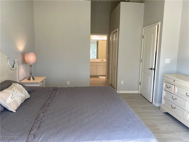 a view of a bedroom with a bed and a lamp