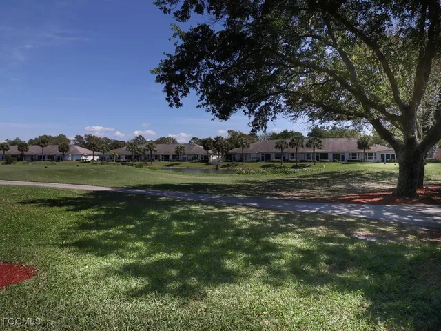 a view of a grassy field with trees around