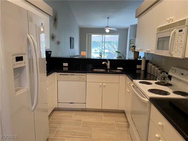 a kitchen with stainless steel appliances a sink a stove a refrigerator and cabinets