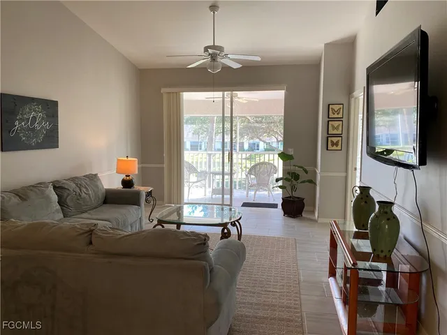 a living room with furniture a flat screen tv and a large window