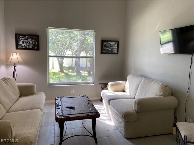 a living room with furniture a window and a flat screen tv