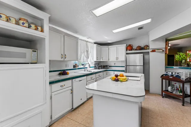 a kitchen with stainless steel appliances granite countertop a sink and a refrigerator