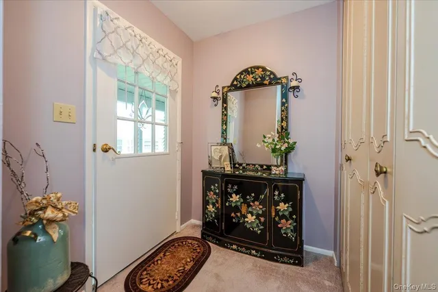 a front view of a fireplace with wooden floor mirror and a window