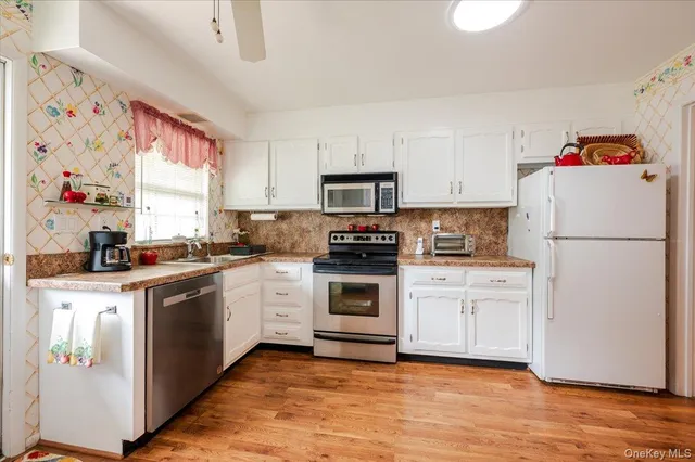 a kitchen with granite countertop white cabinets and white appliances