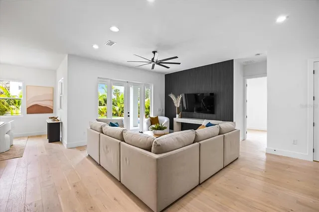 a kitchen with stainless steel appliances granite countertop a dining table chairs and white cabinets