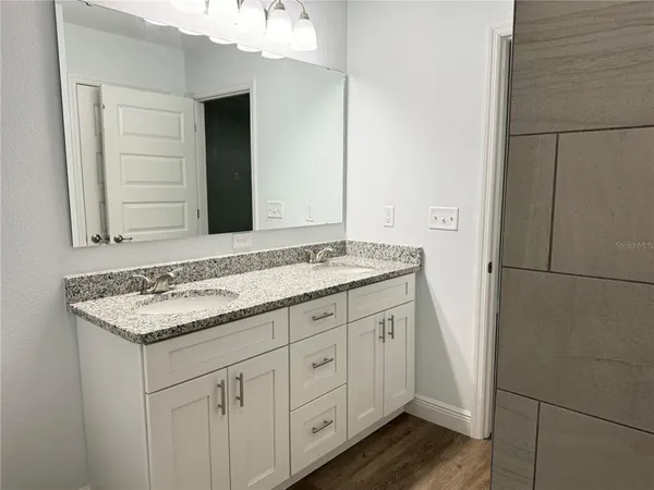 a bathroom with a granite countertop sink and a mirror