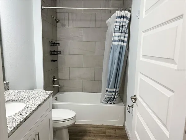 a bathroom with a granite countertop sink toilet and shower