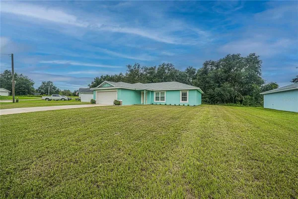 a backyard of a house with lots of green space and outdoor seating