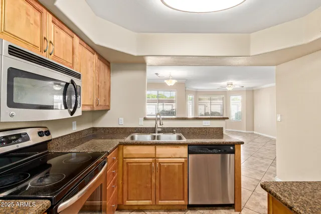 a kitchen with granite countertop a sink a stove and cabinets