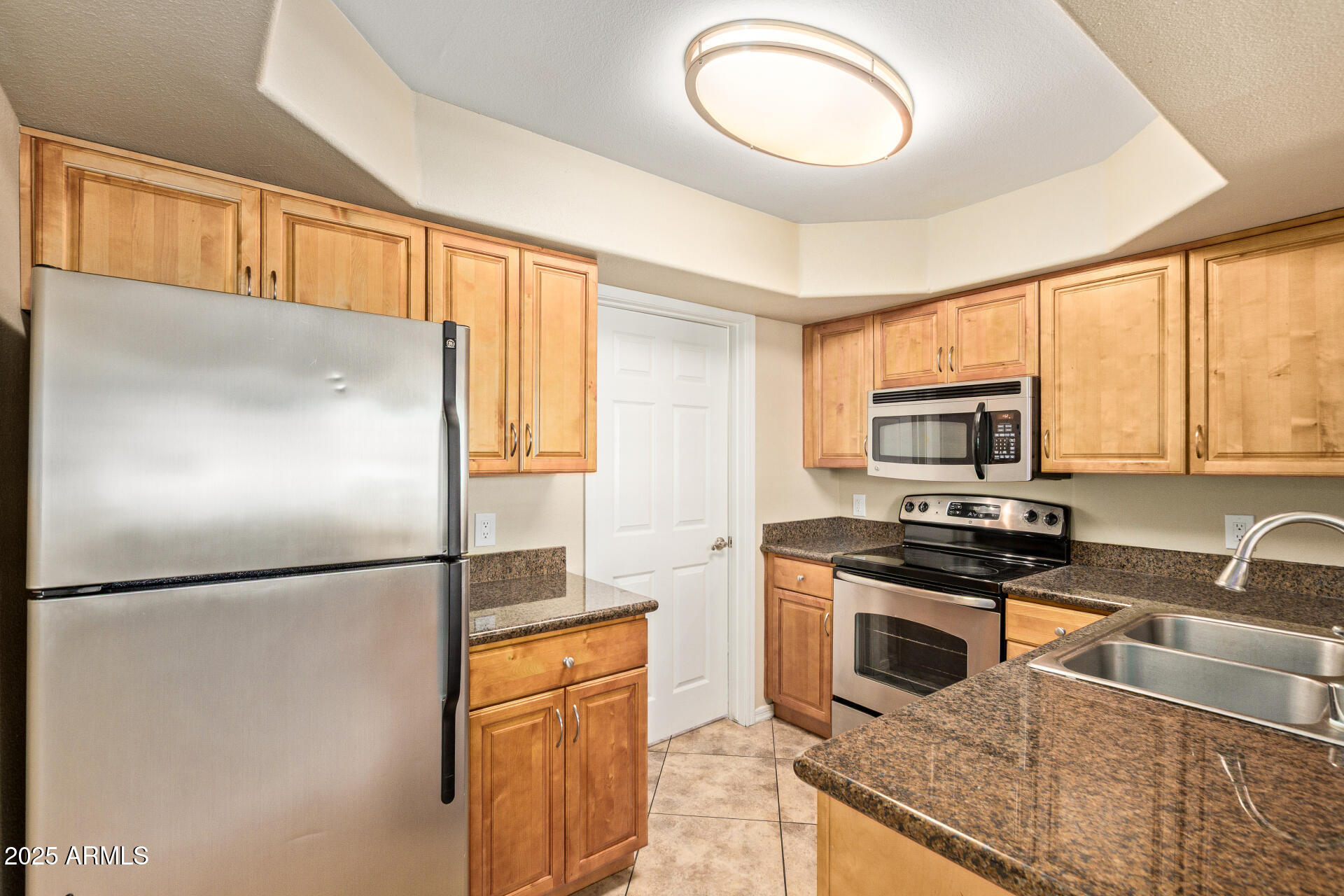 17017 North 12th Street, Unit 1035 Phoenix, AZ 85022 - Photo 2 of 19 a kitchen with stainless steel appliances granite countertop a refrigerator a stove a sink and a microwave