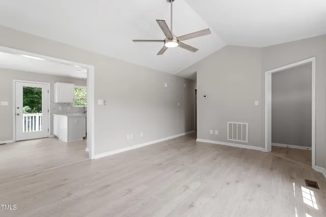 an empty room with fan and windows
