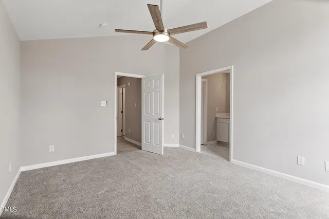 an empty room with closet and fan