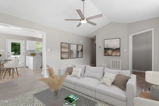 a living room with furniture and a wooden floor