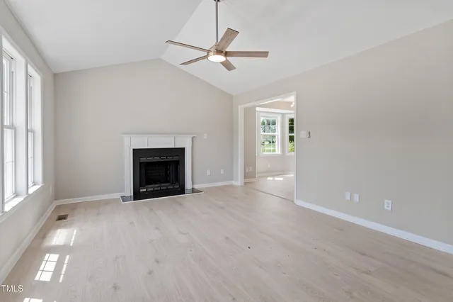 wooden floor fireplace and windows in an empty room