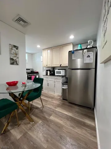 a kitchen with refrigerator and chairs