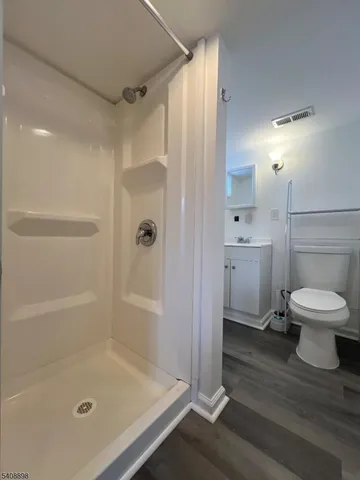 a bathroom with a shower a toilet and a sink