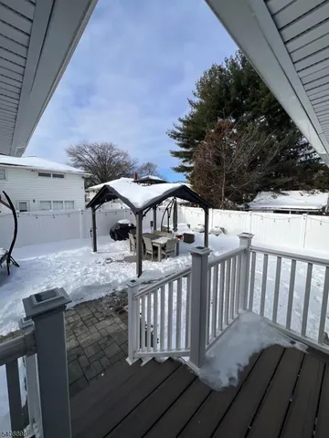 a view of a roof deck with table and chairs with wooden floor and fence
