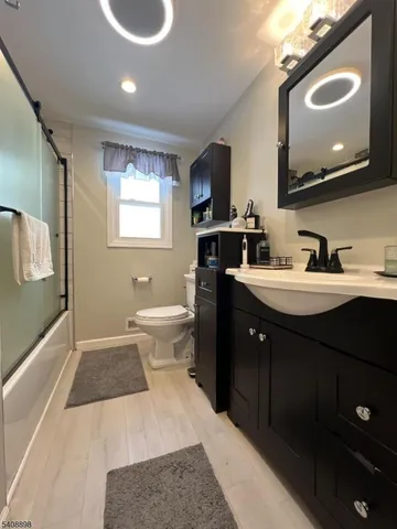 a spacious bathroom with a double vanity sink a mirror and a toilet