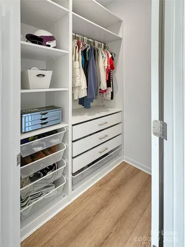 a view of walk in closet with clothes and shoes