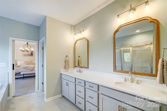 a en suite bathroom with a double vanity sink and a mirror