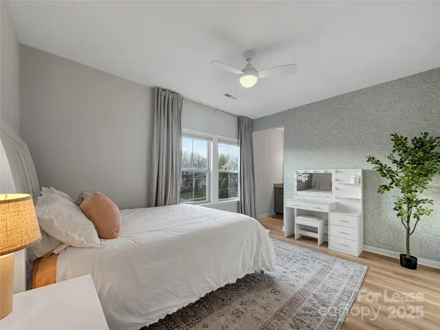 a bedroom with a bed table chair and a window