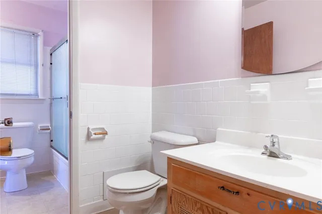 a bathroom with a granite countertop toilet sink and mirror