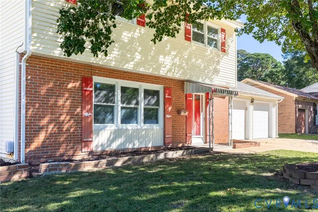 a front view of a house with a garden and plants