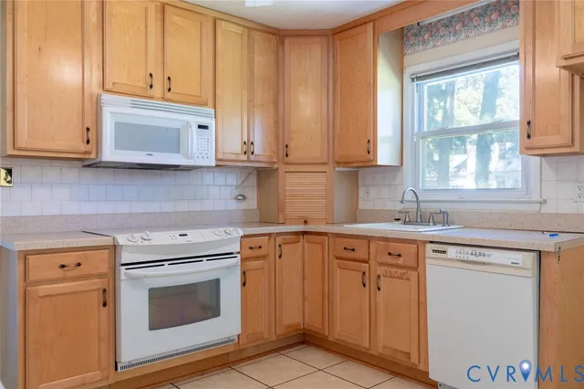 a kitchen with cabinets appliances a sink and a window