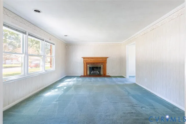 an empty room with windows and fireplace