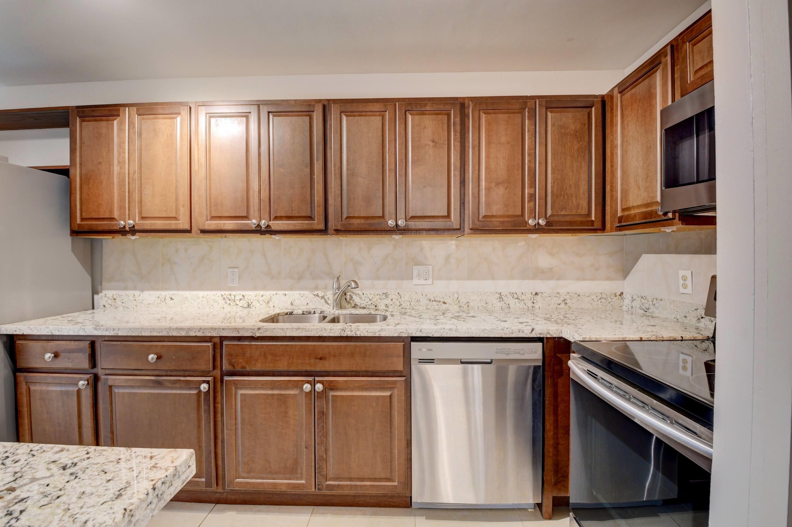 21748 Juego Circle, Unit 21E Boca Raton, FL 33433 - Photo 26 of 56 a kitchen with granite countertop a sink stove and cabinets