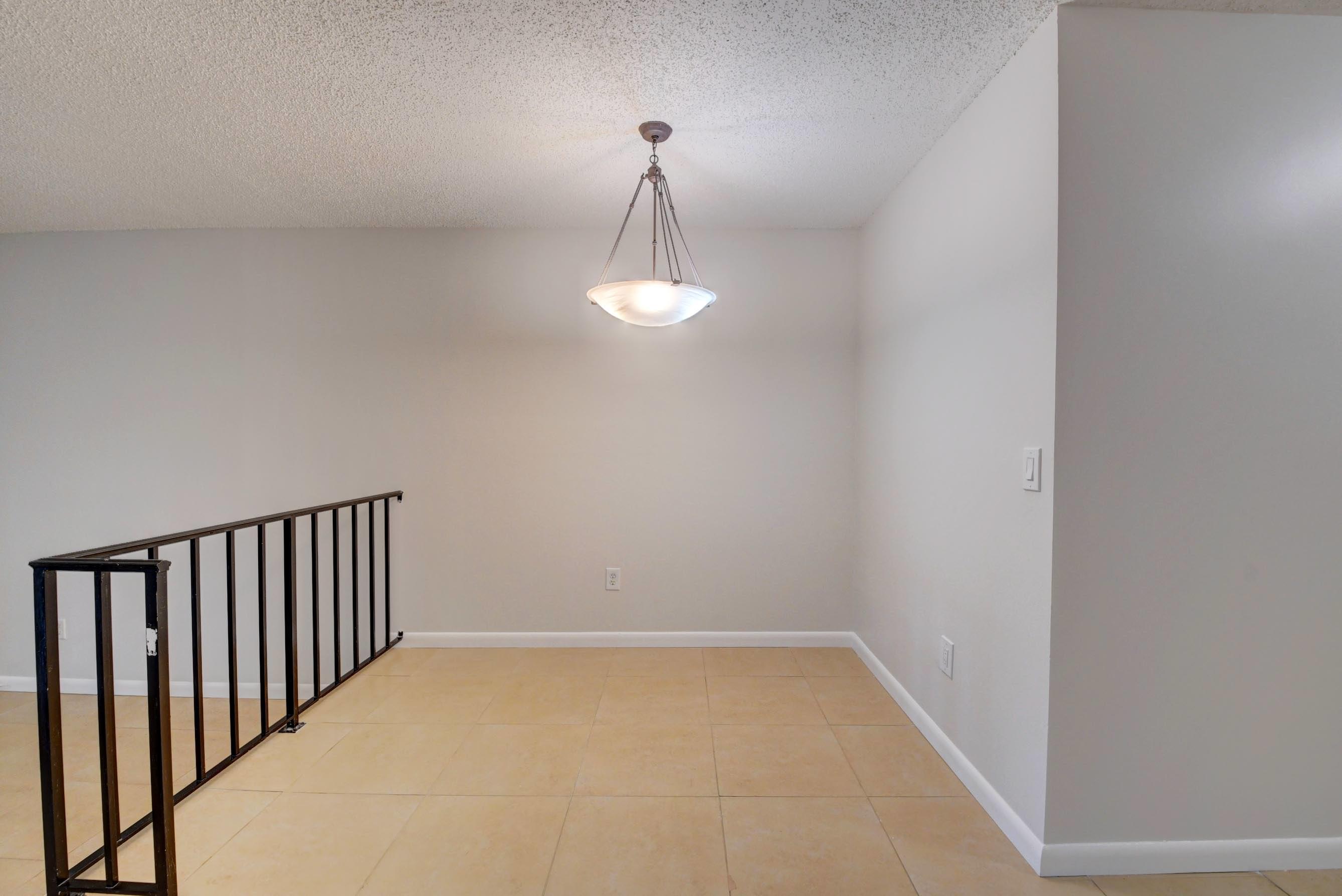 21748 Juego Circle, Unit 21E Boca Raton, FL 33433 - Photo 27 of 56 a view of a hallway with a chandelier fan