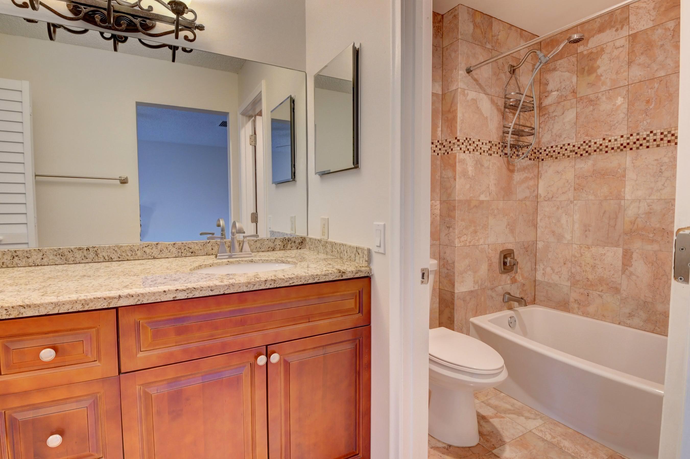 21748 Juego Circle, Unit 21E Boca Raton, FL 33433 - Photo 50 of 56 a bathroom with a granite countertop sink toilet and shower