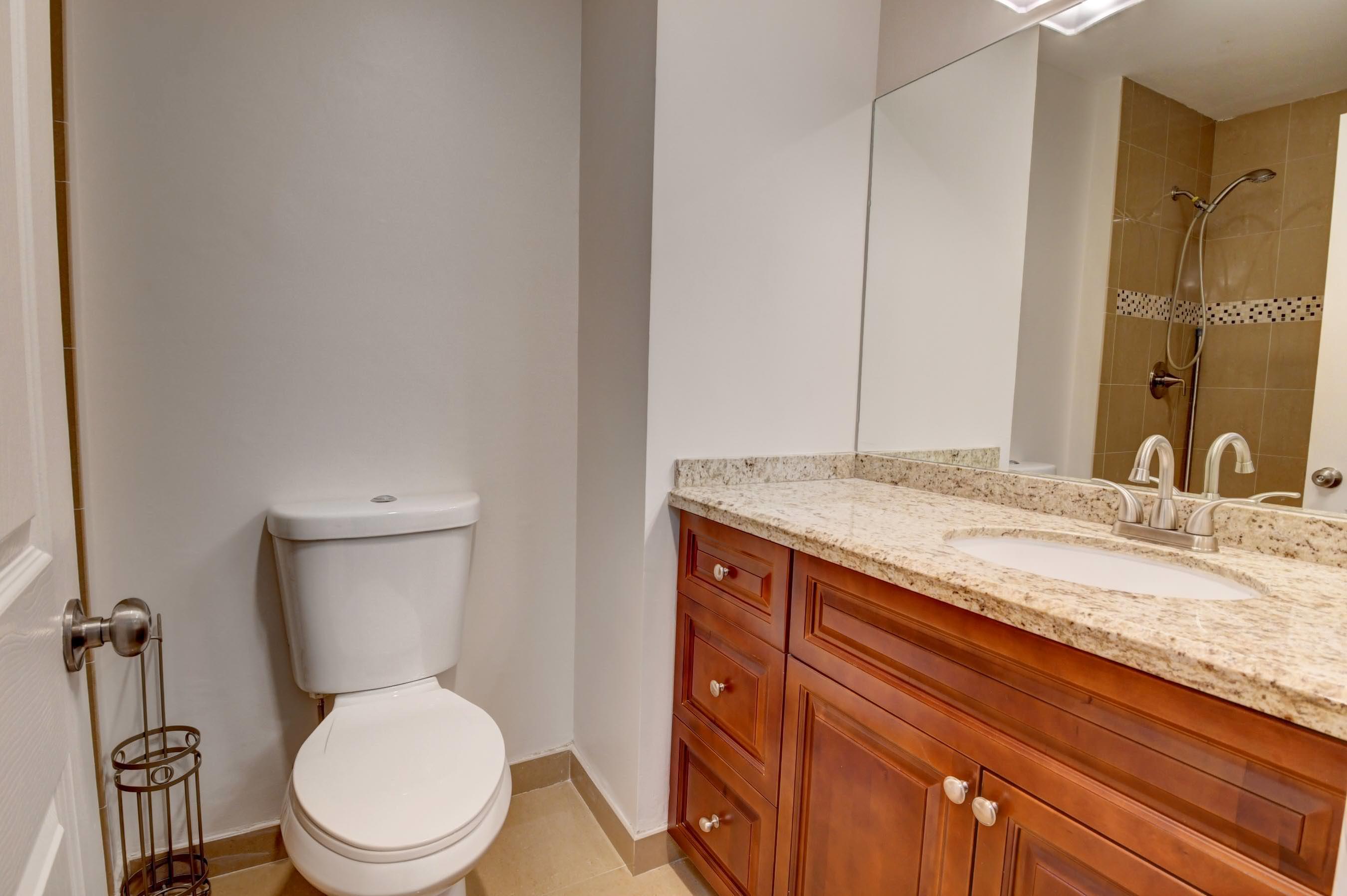21748 Juego Circle, Unit 21E Boca Raton, FL 33433 - Photo 54 of 56 a bathroom with a granite countertop toilet sink and mirror