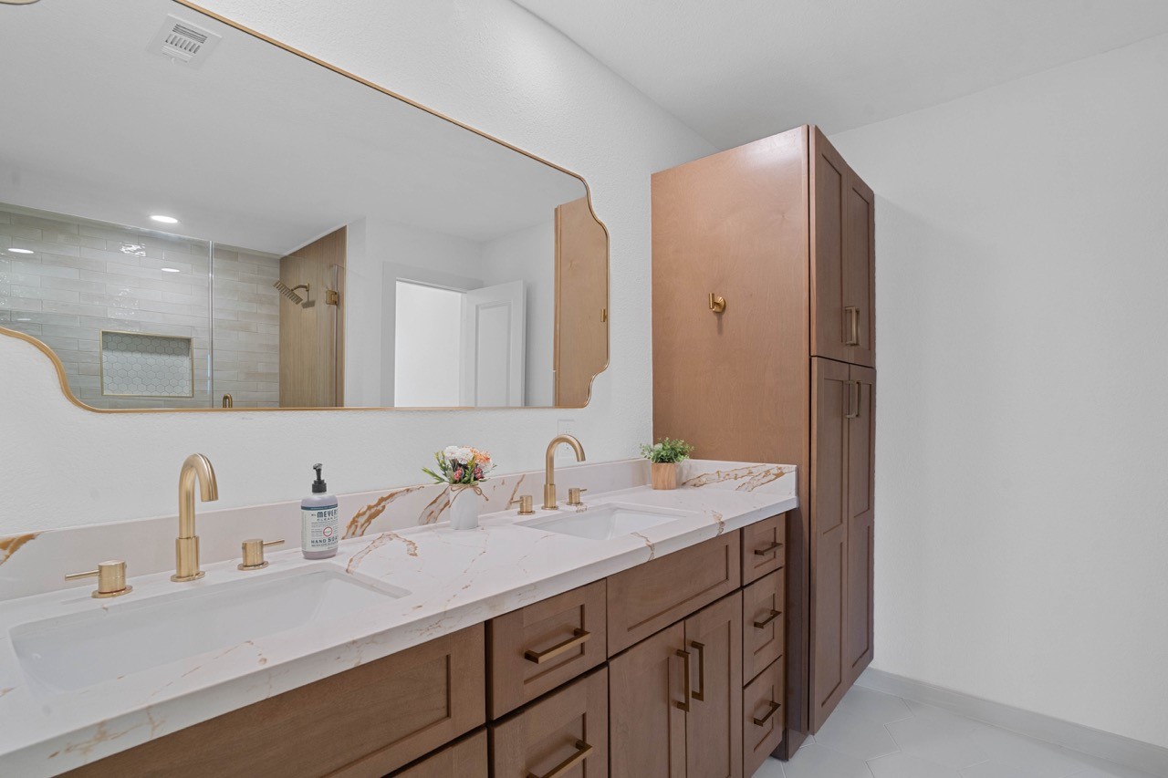 5326 Findlay Drive Pasadena, TX 77505 - Photo 33 of 50 Luxurious primary bathroom featuring dual quartz vanities, designer fixtures, and a full-height linen cabinet for added storage.
