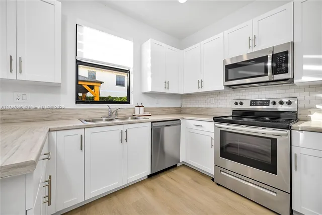 a kitchen with stainless steel appliances granite countertop a stove microwave and sink