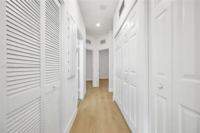 a view of a hallway with a white wooden cabinets