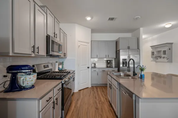 a kitchen with stainless steel appliances granite countertop a sink stove and refrigerator