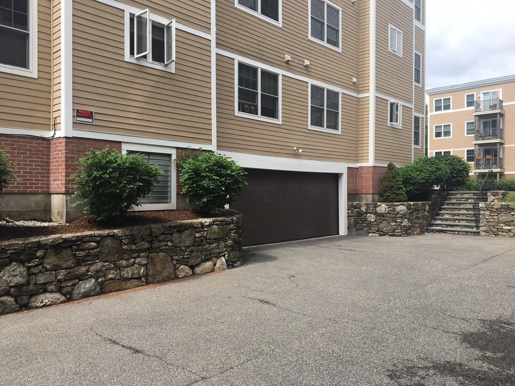 11 Cheriton Road, Unit 307 Boston, MA 02132 - Photo 11 of 12 a front view of a house with a yard and garage
